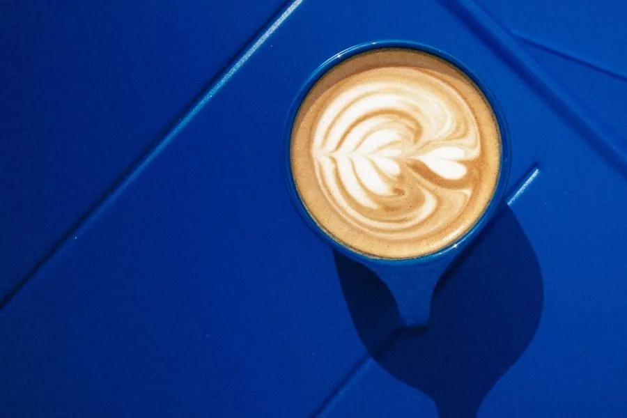 Cappuccino with latte art on the blue ledge of the kiosk